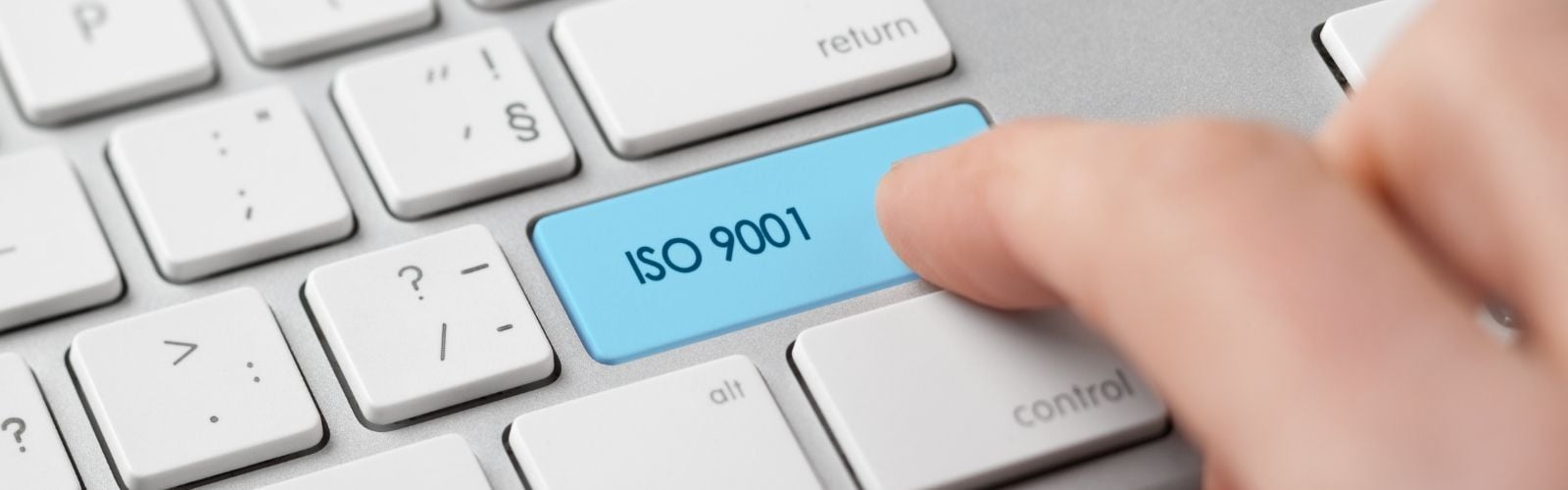Finger klickt auf Taste mit ISO 9001
