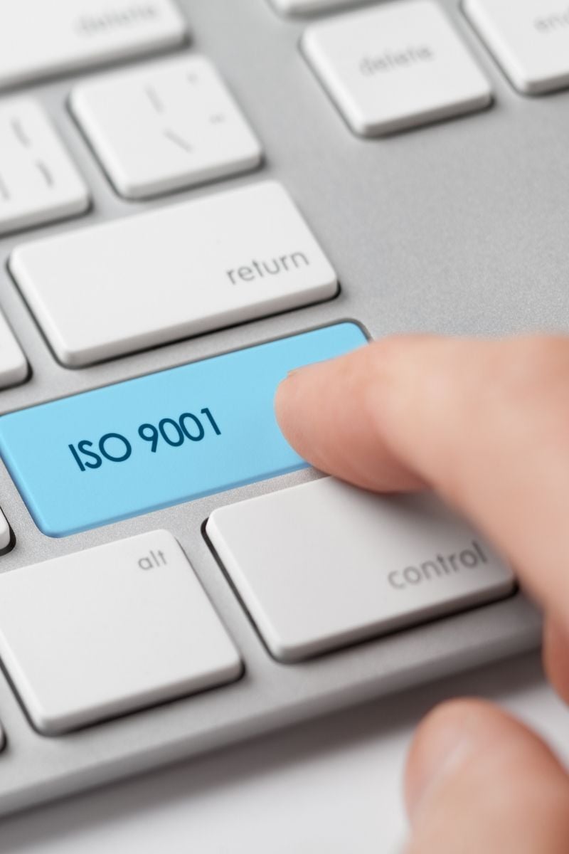 Finger klickt auf Taste mit ISO 9001